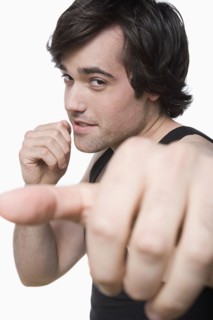 Studio portrait of young man punching air. Photo : Rob Lewine