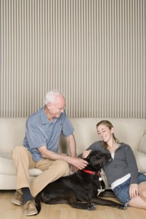 Grandfather with granddaughter (14-15) stroking dog . Photo : Rob Lewine
