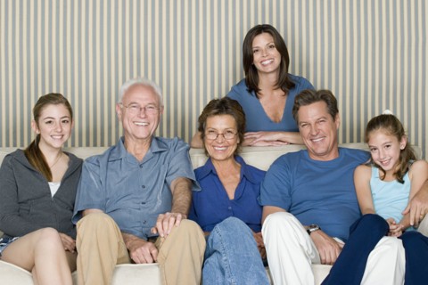 Portrait of two generation family with two girls (8-9, 14-15) sitting on sofa. Photo : Rob Lewine