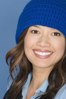 Portrait of happy asian woman wearing blue knit hat. Photo : Rob Lewine