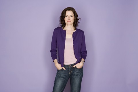 Portrait of smiling woman on purple background, studio shot. Photo : Rob Lewine