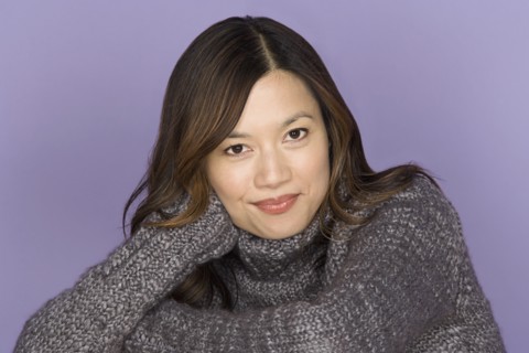 Portrait of smiling woman on purple background, studio shot. Photo : Rob Lewine