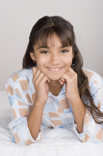 Portrait of smiling girl (10-11) in pajamas. Photo : Rob Lewine