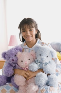 Portrait of smiling girl (10-11) holding puppets. Photo : Rob Lewine