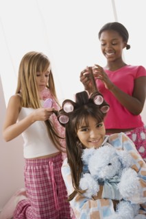 Three girls (10-11) doing hair at slumber party. Photo : Rob Lewine