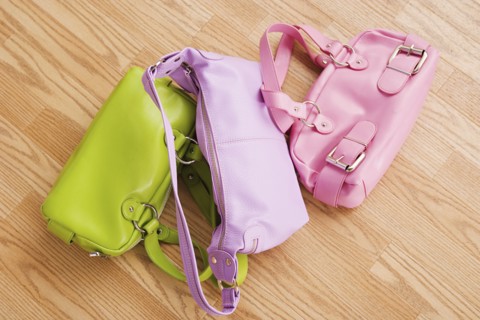 Close up of three colorful purses on parquet floor. Photo : Rob Lewine