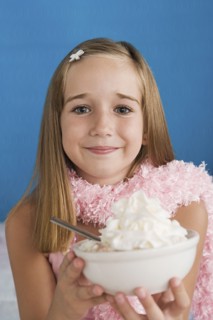 Portrait of girl (10-11) holding bowl with whipped cream. Photo : Rob Lewine