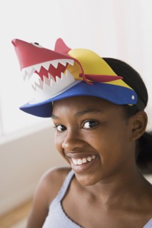 Portrait of smiling girl (10-11) wearing funny hat. Photo : Rob Lewine