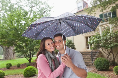 USA, New Jersey, Portrait of couple holding umbrella. Photo : Tetra Images