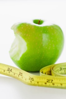 Green apple with tape measure.