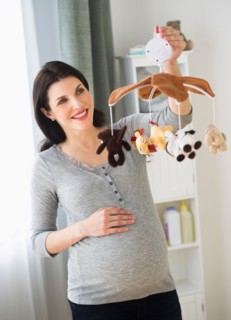 Expectant mother decorating baby room.