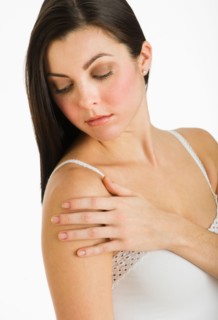 Studio shot of young woman caring for skin.
