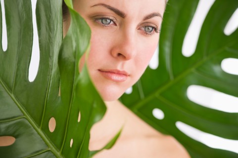 Studio shot of woman between leaves.