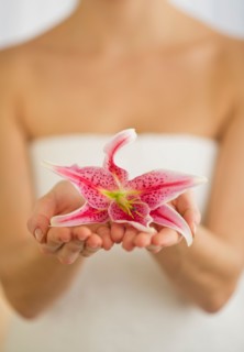 Studio shot of woman holding lily.