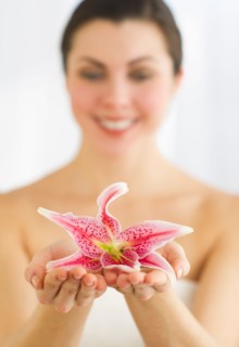 Studio shot of woman holding lily.
