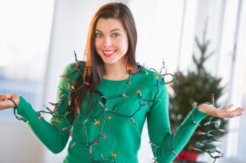 Portrait of woman tangled in Christmas lights.