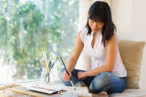 Mid adult woman painting at home.