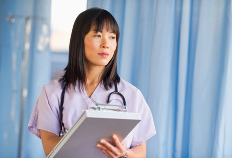 Doctor noting in medical chart of clipboard.