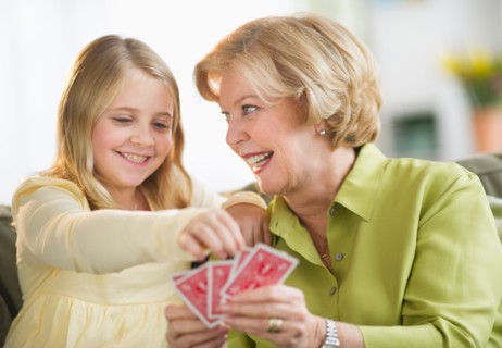 Grandmother with granddaughter (8-9) playing cards.