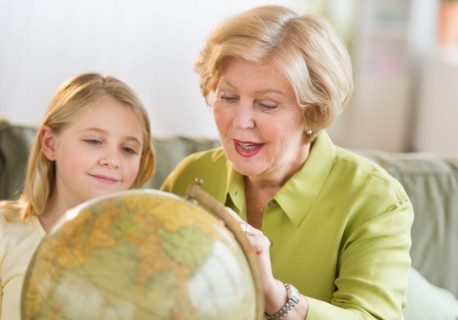 Grandmother with granddaughter (8-9) looking at globe.