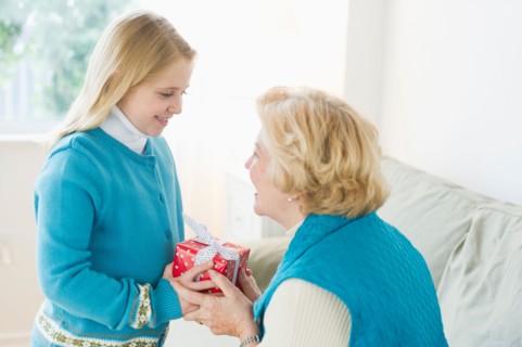 Granddaughter (8-9) receiving gift from grandmother.
