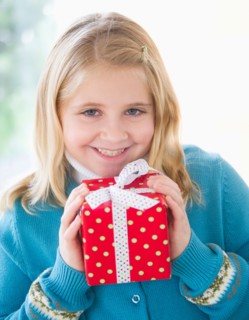 Portrait of smiling girl (8-9) holding gift.