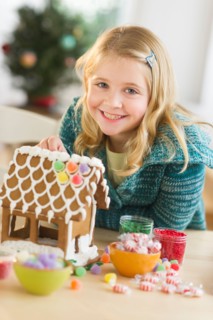 Girl (8--9) making gingerbread house.