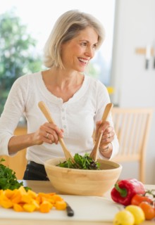JPortrait of senior woman preparing salad in kitchen.