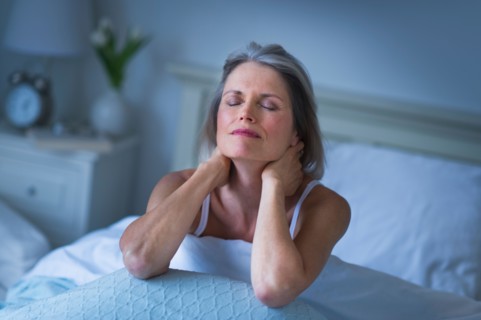 Senior woman sitting in bed and suffering from necklace.