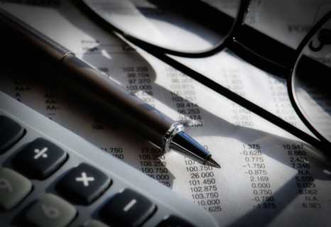 Close up of pen, glasses and calculator, studio shot.