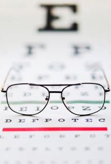 Close up of glasses on eye chart, studio shot.