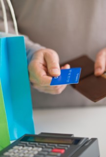 Close up of man's hands holding credit card and wallet, studio shot.