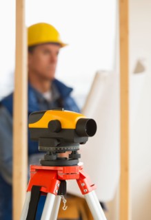 Construction worker with theodolite.