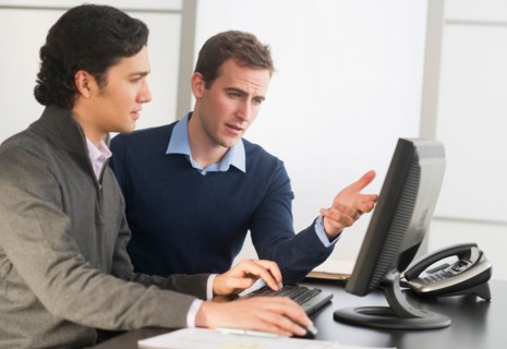 Two businessmen working at desk.