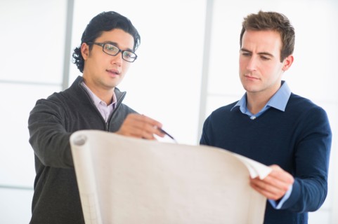 Two businessmen discussing blueprint.