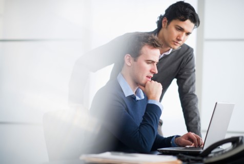 Two businessmen working with laptop.