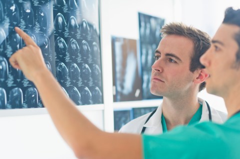 Two male doctors discussing x-ray images.
