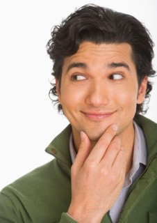 Studio shot of young man looking surprised and happy.