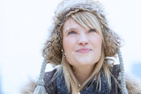 Portrait of woman wearing knit hat smiling.