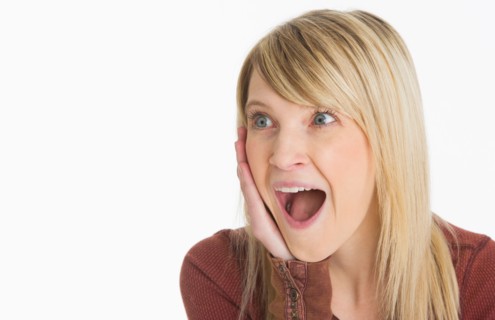 Studio portrait of woman looking surprised.