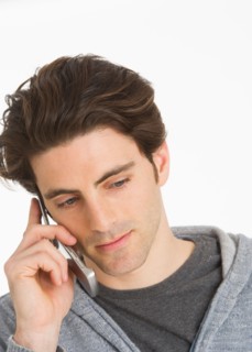 Studio portrait of man talking on mobile phone.