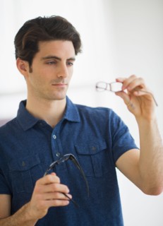 Man looking at spectacles in store.