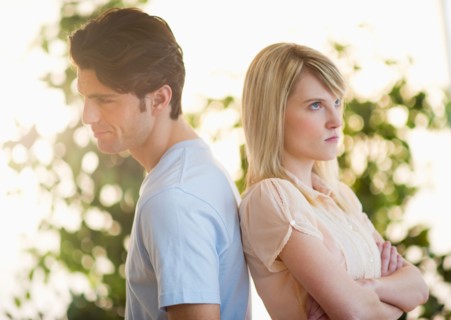 Angry couple standing back to back.
