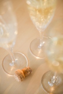 Champagne flutes and cork on table. Photo : Jamie Grill