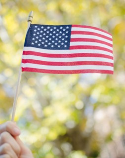 hand holding American flag. Photo : Jamie Grill