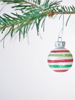 Studio shot of striped Christmas ornament hanging on Christmas tree. Photo : Daniel Grill