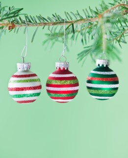 Studio shot of striped Christmas ornaments hanging on Christmas tree. Photo : Daniel Grill