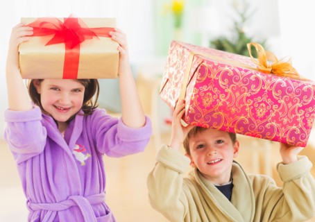 Girl (8-9) and boy (6-7) carrying christmas gifts on their heads. Photo : Daniel Grill