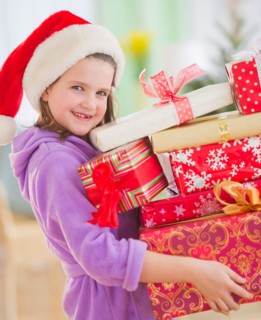 Girl (8-9) carrying christmas gifts. Photo : Daniel Grill