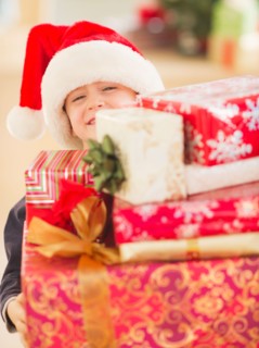 Boy (6-7) carrying christmas gifts. Photo : Daniel Grill